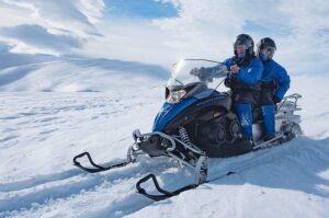 Two riders sharing a snowmobile on Vatnajökull