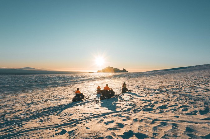 A group of snowmobilers on a snowy landscape on the Langjökull tour from Reykjavík